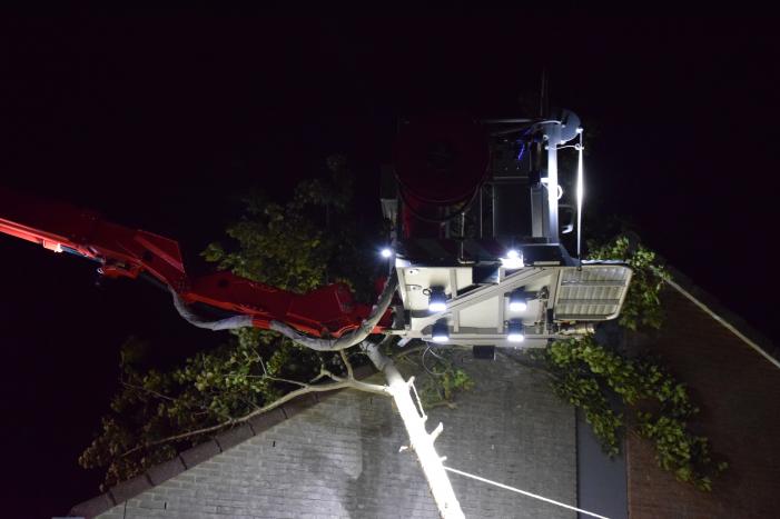 Boom waait om tegen woning