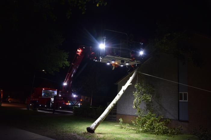 Boom waait om tegen woning