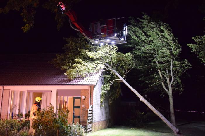 Boom waait om tegen woning