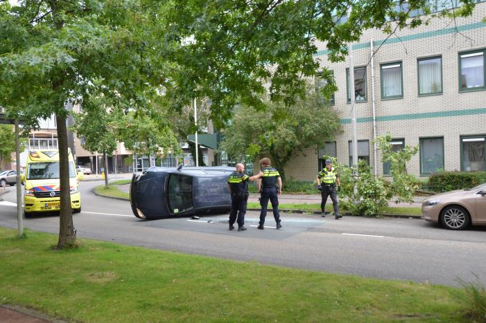 Auto vliegt uit de bocht en belandt op zijn kant