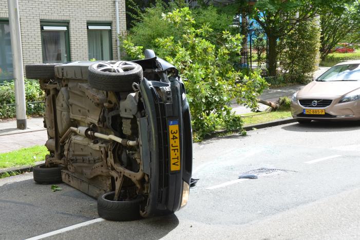 Auto vliegt uit de bocht en belandt op zijn kant