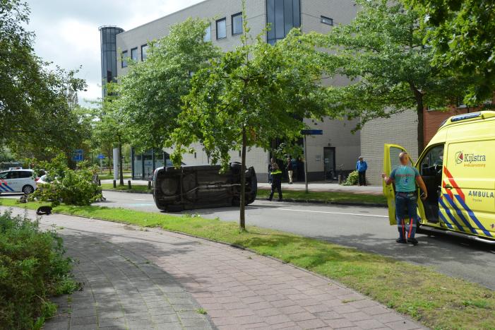 Auto vliegt uit de bocht en belandt op zijn kant