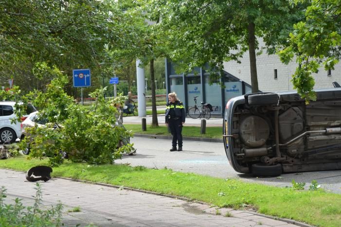 Auto vliegt uit de bocht en belandt op zijn kant