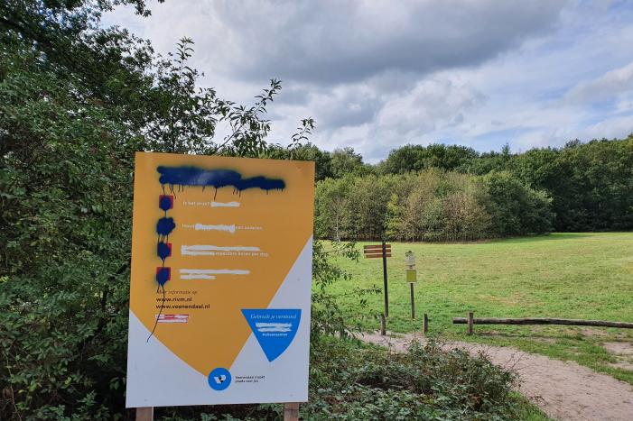 Corona COVID-19 waarschuwingsbord gemolesteerd bij bosrand