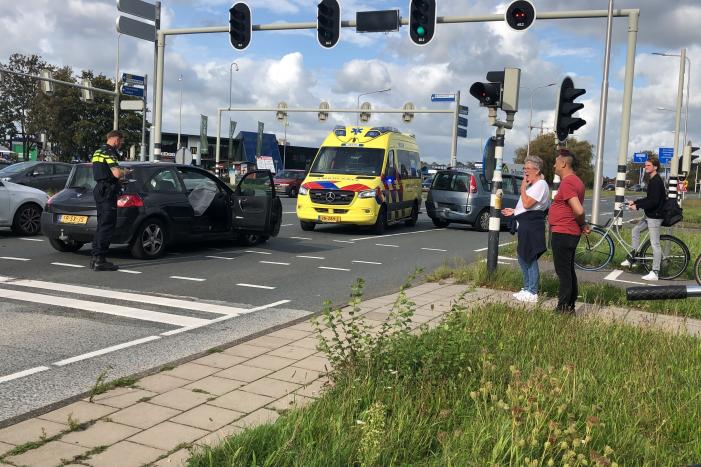 Twee auto's botsen op elkaar voor stoplicht