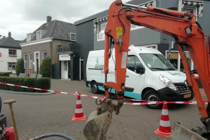 Straat opengebroken door gesprongen waterleiding