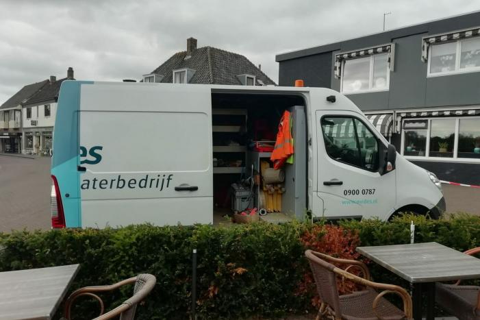 Straat opengebroken door gesprongen waterleiding
