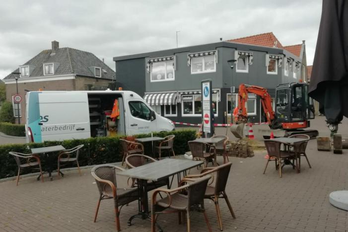 Straat opengebroken door gesprongen waterleiding