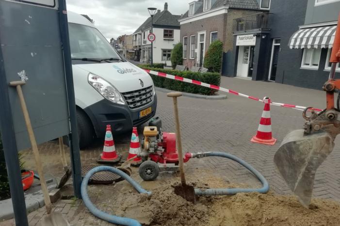 Straat opengebroken door gesprongen waterleiding