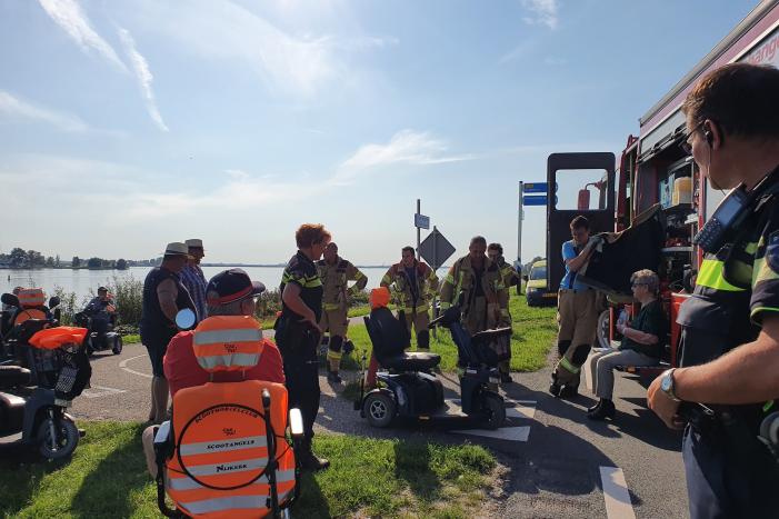 Vrouw rijdt met scootmobiel op verkeerspaal