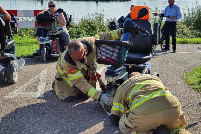 Vrouw rijdt met scootmobiel op verkeerspaal