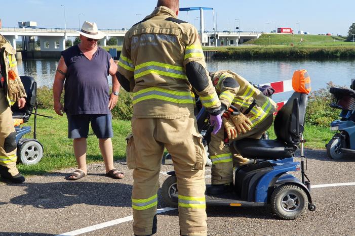Vrouw rijdt met scootmobiel op verkeerspaal