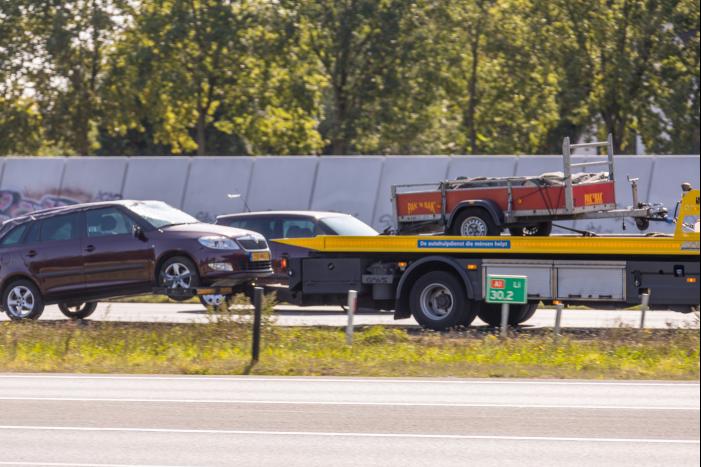 Auto met aanhanger geschaard op snelweg