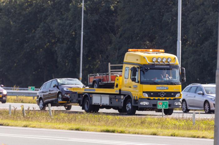Auto met aanhanger geschaard op snelweg