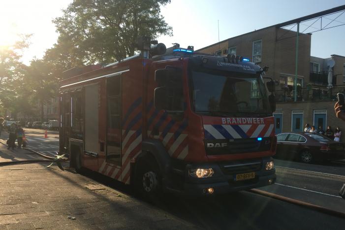 Boom achter woonblok vliegt in brand
