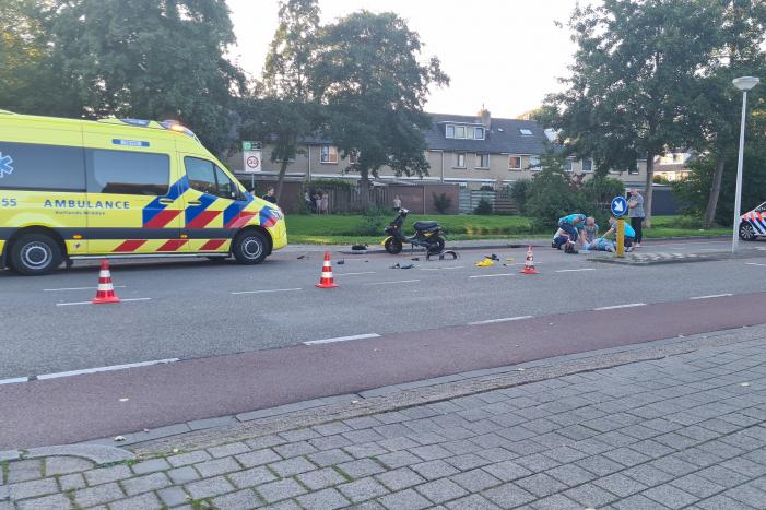 Taxi en scooter botsen op kruising