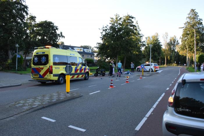 Taxi en scooter botsen op kruising