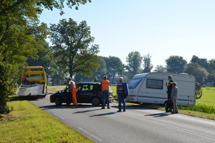Auto met caravan raakt van de weg