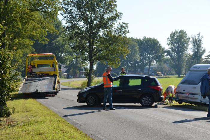 Auto met caravan raakt van de weg