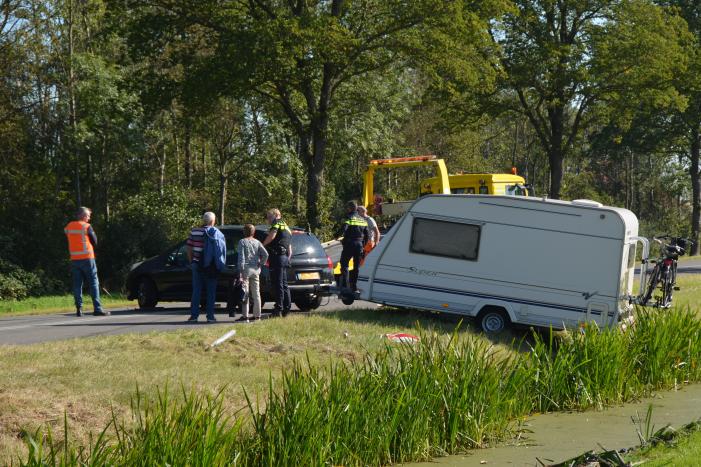 Auto met caravan raakt van de weg