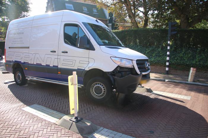 Bestelbus komt vast te zitten op paal van bussluis