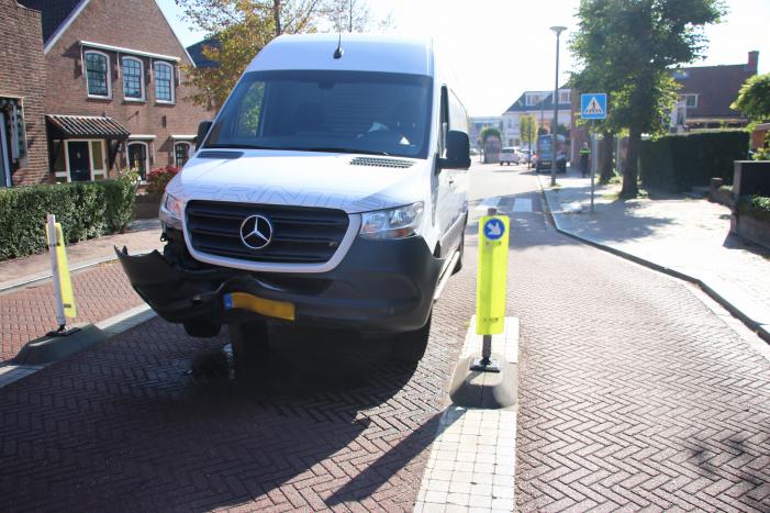 Bestelbus komt vast te zitten op paal van bussluis