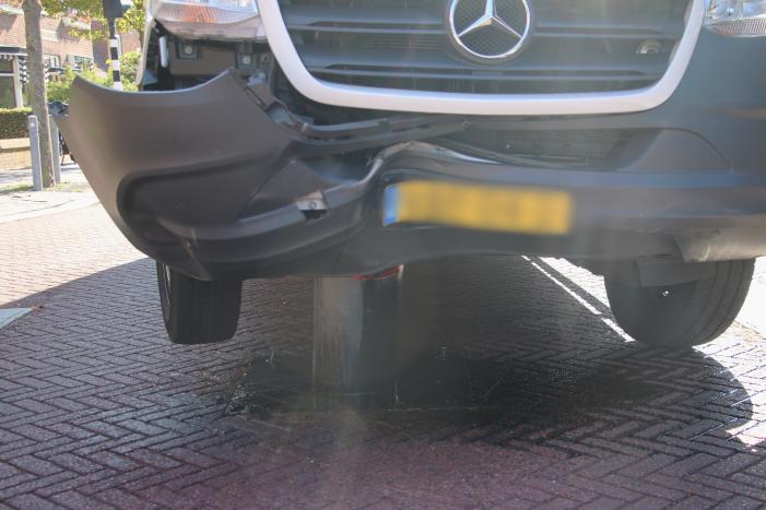 Bestelbus komt vast te zitten op paal van bussluis