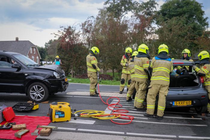 Vrouw bekneld in voertuig bij aanrijding op kruising