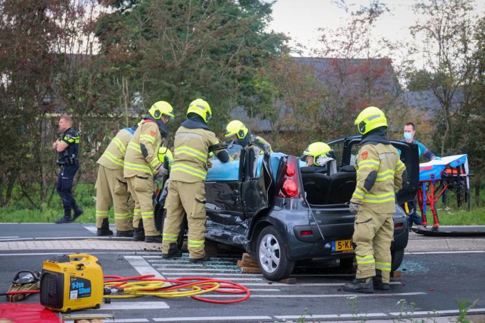 Vrouw bekneld in voertuig bij aanrijding op kruising