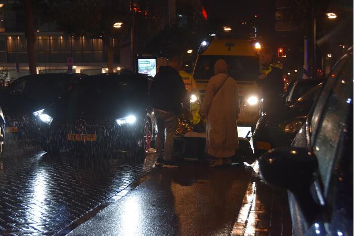 Scooterrijder valt met scooter tegen auto