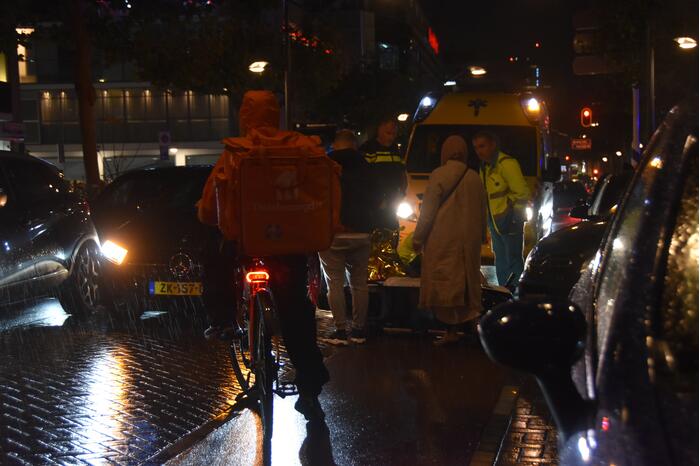 Scooterrijder valt met scooter tegen auto