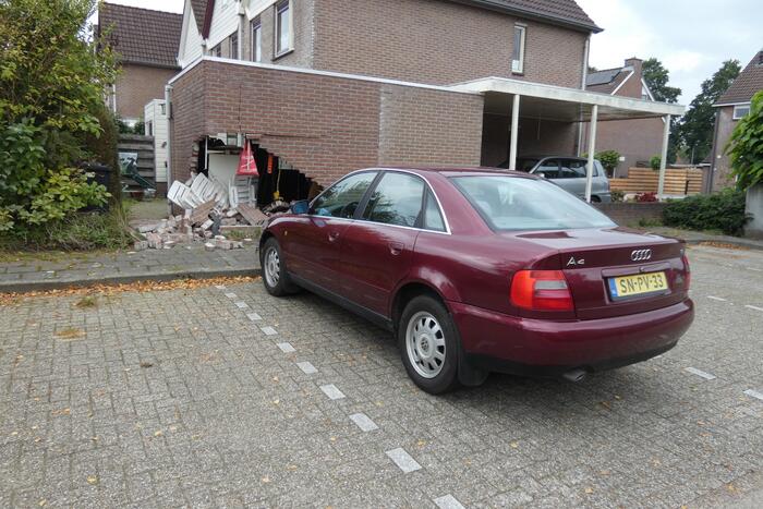 Automobilist rijdt garage in bij wegrijden