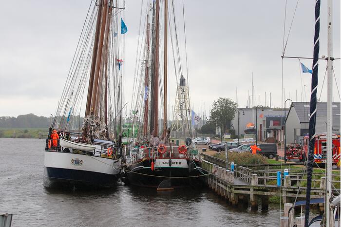 Brandweer plaats olieschermen voor lekkend zeilschip