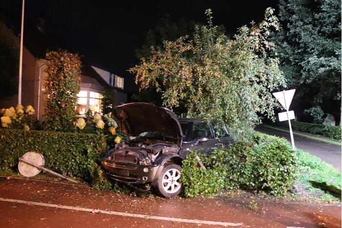 Auto rijdt heg in na botsing