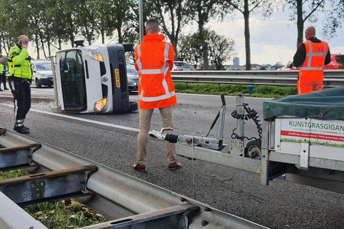 Bestelbus met aanhanger kantelt op snelweg