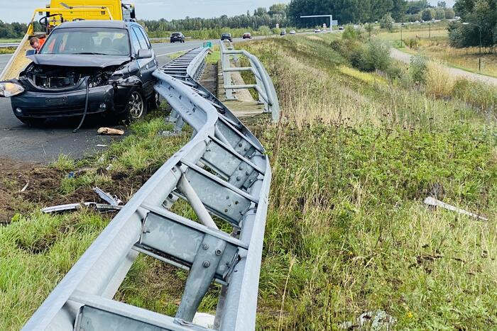 Auto belandt op toerit van snelweg in vangrail