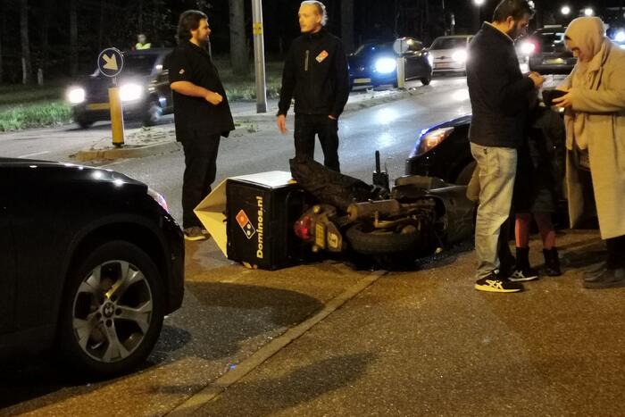 Maaltijdbezorger botst op kruising met auto