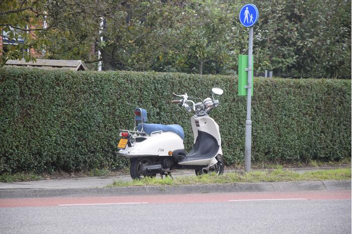 Personenauto ziet scooterrijder over het hoofd