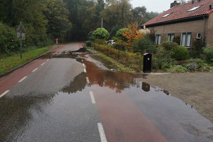 Straat onder water door gesprongen waterleiding