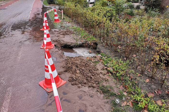 Straat onder water door gesprongen waterleiding