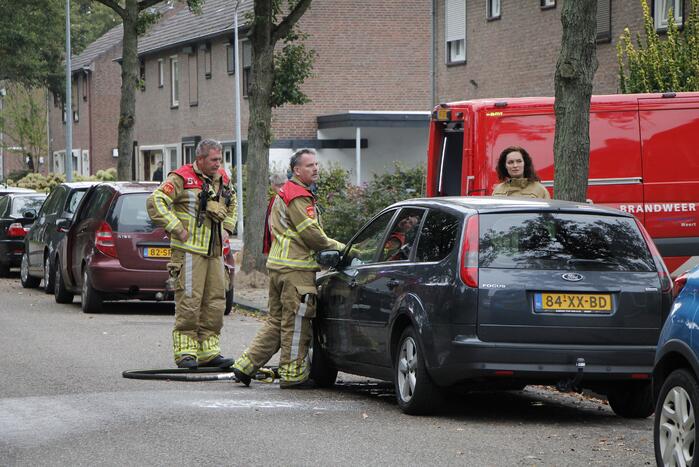 Brandweer blust brand in motorkap