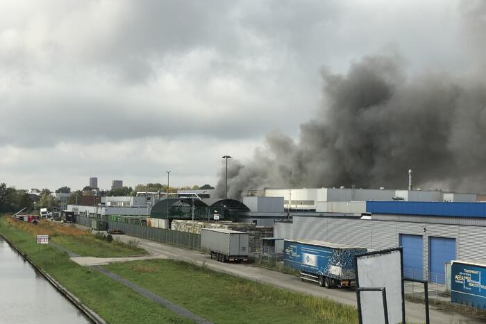 Dikke rookwolken boven industrieterrein bij brand in pand Sims Lifecycle Services