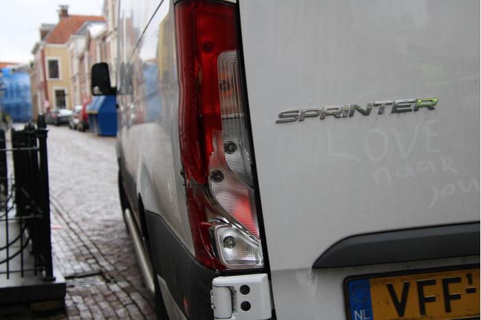 Gefrustreerde fietser trapt achterlicht bestelbus stuk