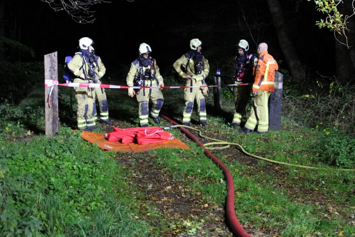 Brand in schuur in bos