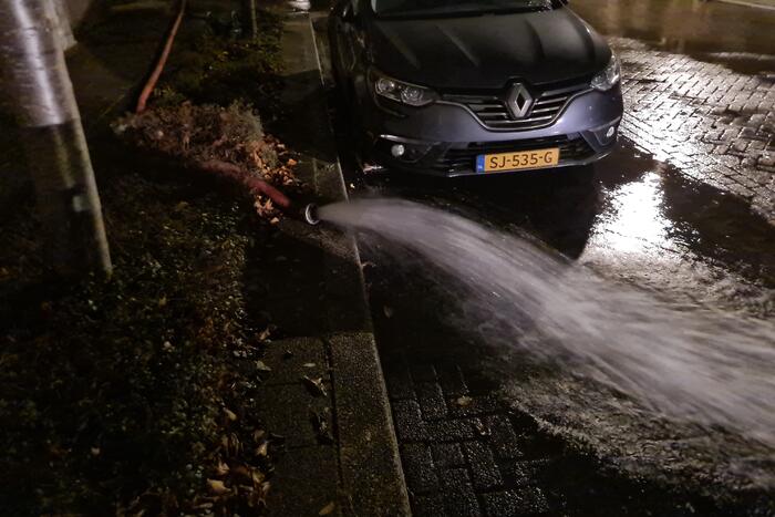 Straat onderwater door gesprongen hoofdwaterleiding