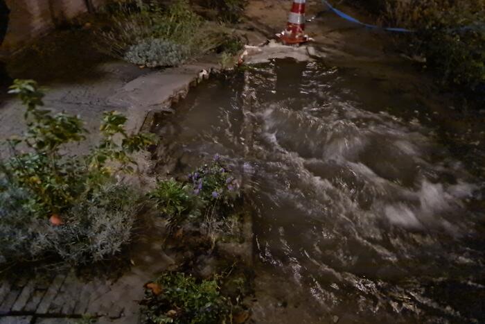 Straat onderwater door gesprongen hoofdwaterleiding