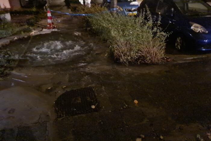 Straat onderwater door gesprongen hoofdwaterleiding