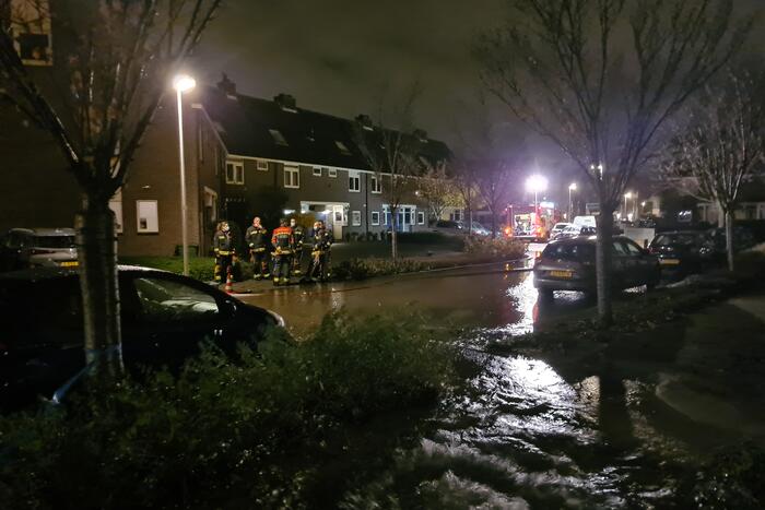 Straat onderwater door gesprongen hoofdwaterleiding