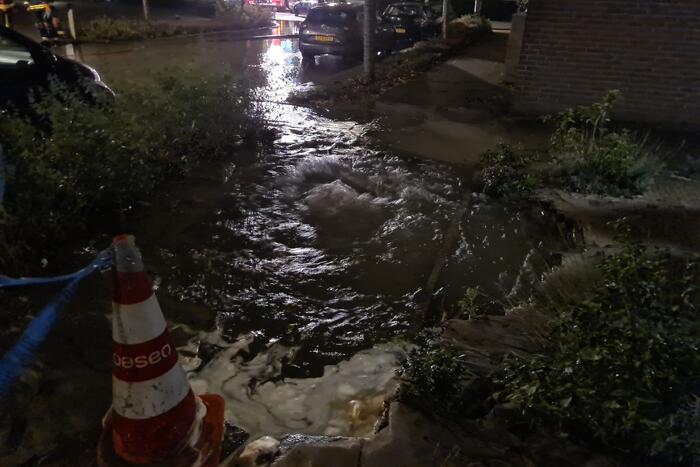 Straat onderwater door gesprongen hoofdwaterleiding