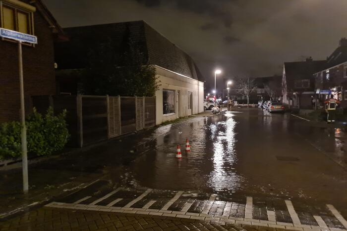 Straat onderwater door gesprongen hoofdwaterleiding